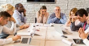 Upset workers at a meeting table